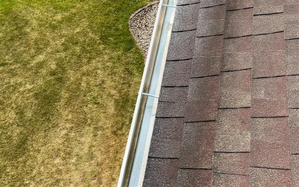 Clean gutter along a shingled roof edge after a Go To Cleaning gutter cleaning